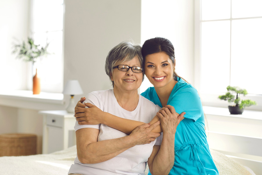 caregiver hugging elderly