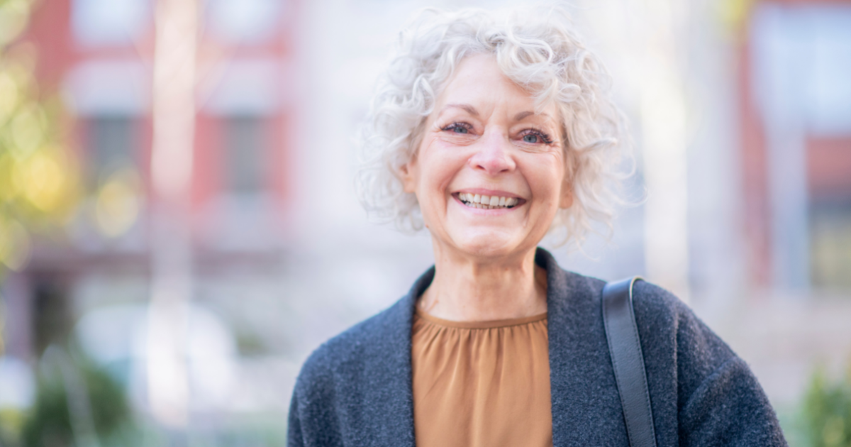 A woman is happy despite dealing with senior incontinence.